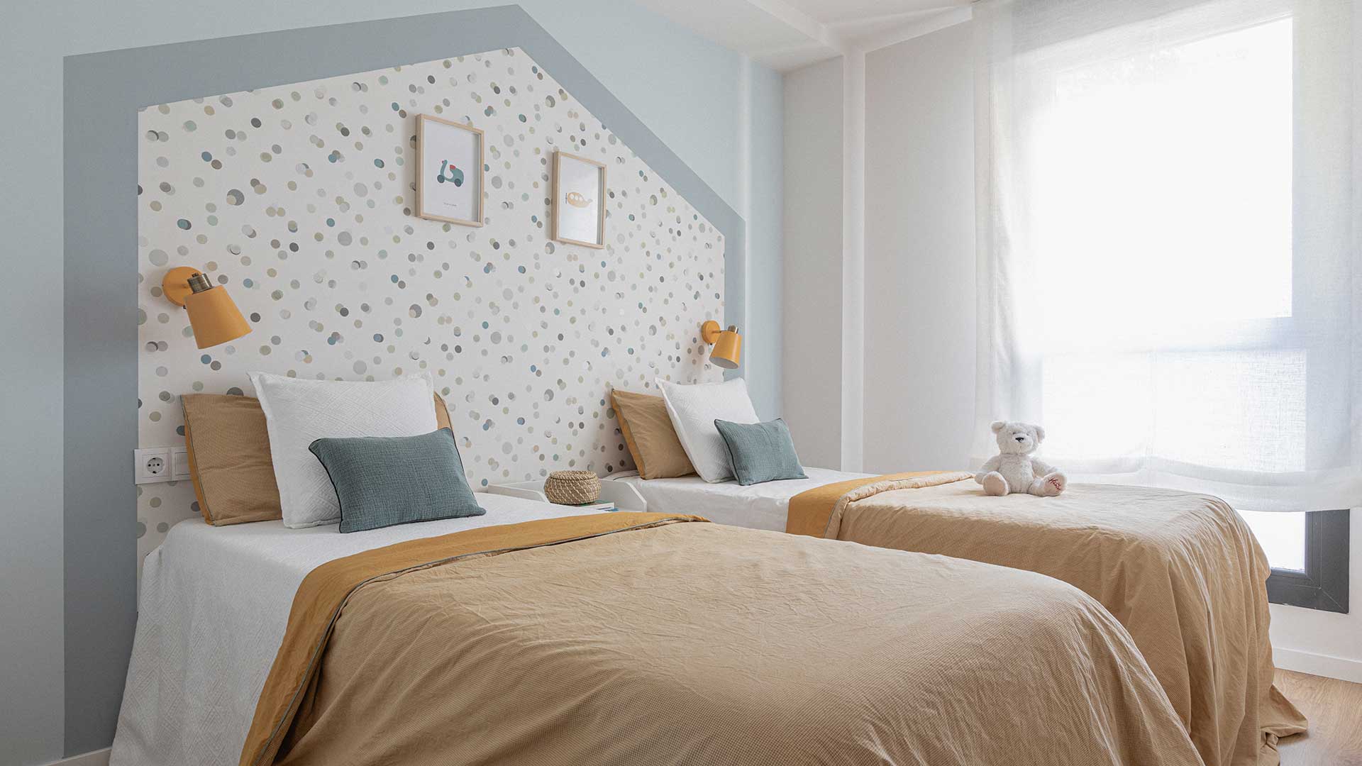 Dormitorio infantil con dos camas y papel pintado con forma de casita. Solo un instante para Moralima Studio.