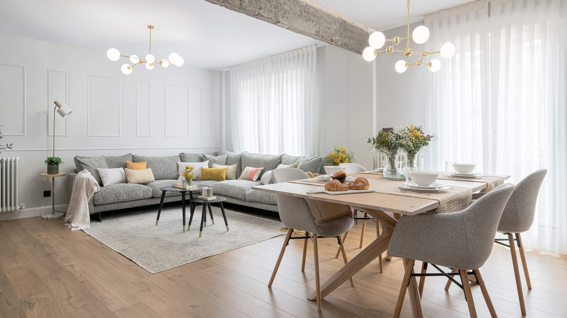 Salón con sofá gris, tonos neutros y madera, reformado por Moralima Studio
